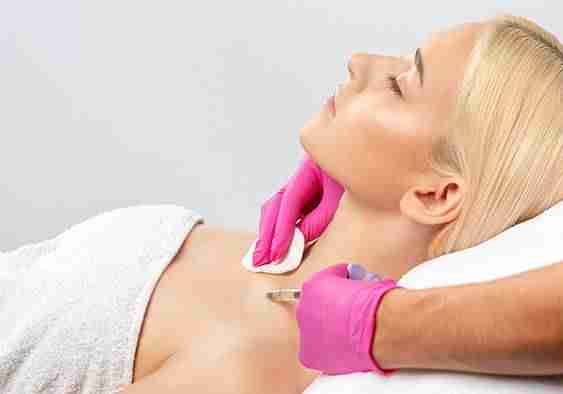 woman in towel relaxes as she gets ready for a botox injection for neck pain