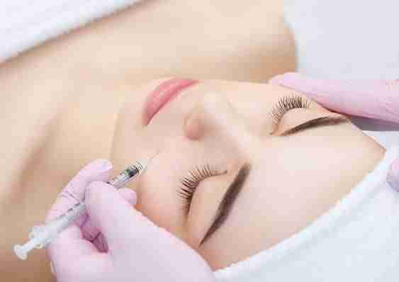 practitioner administering injectable into patient's cheek