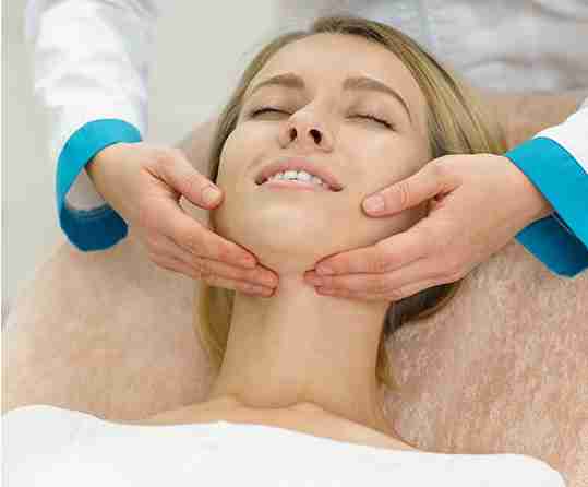 a girl getting a skincare massage on the face by a practitioner