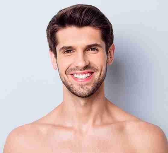 a man with a beard and no shirt smiling