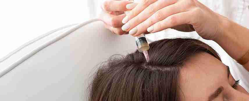 Young woman with hair loss problem receiving injection, close up.